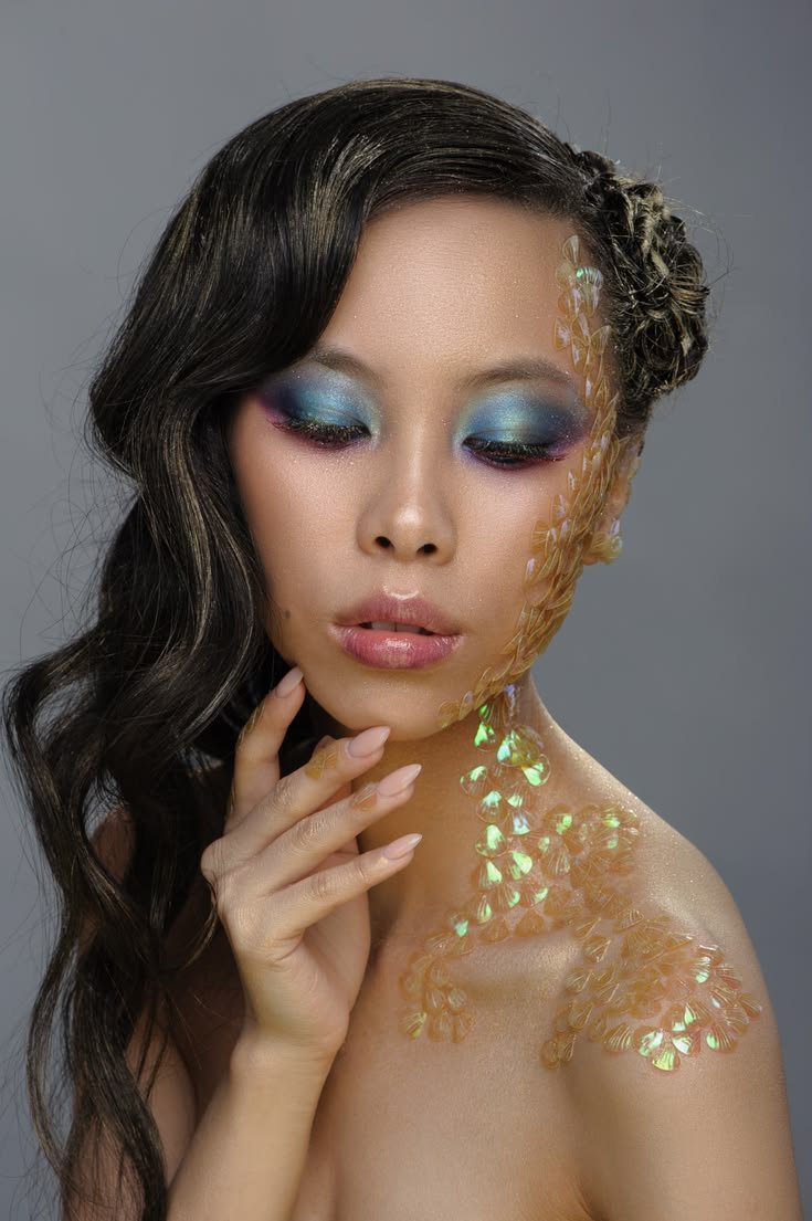 Applying chunky glitter to dark mermaid makeup for a shimmering effect