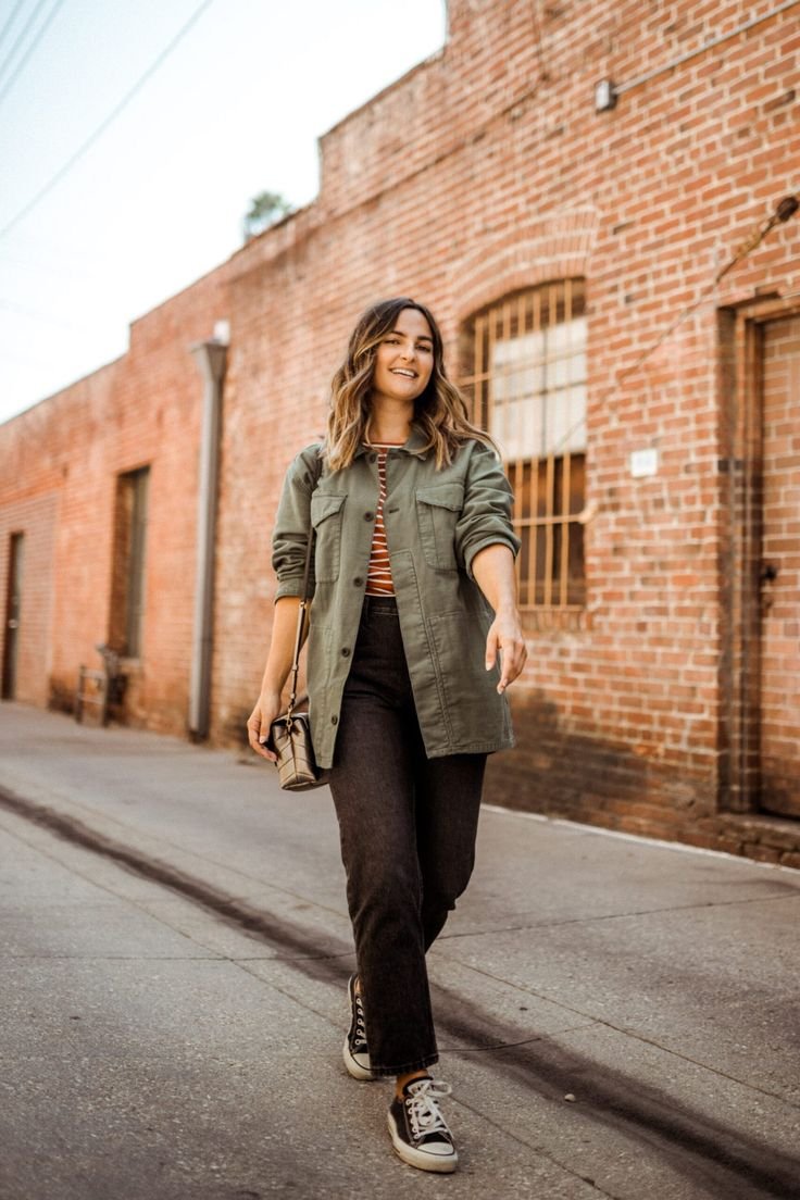 Woman in a dressed-up utility shirt outfit, featuring a tucked-in shirt, tailored pants, and heels.
