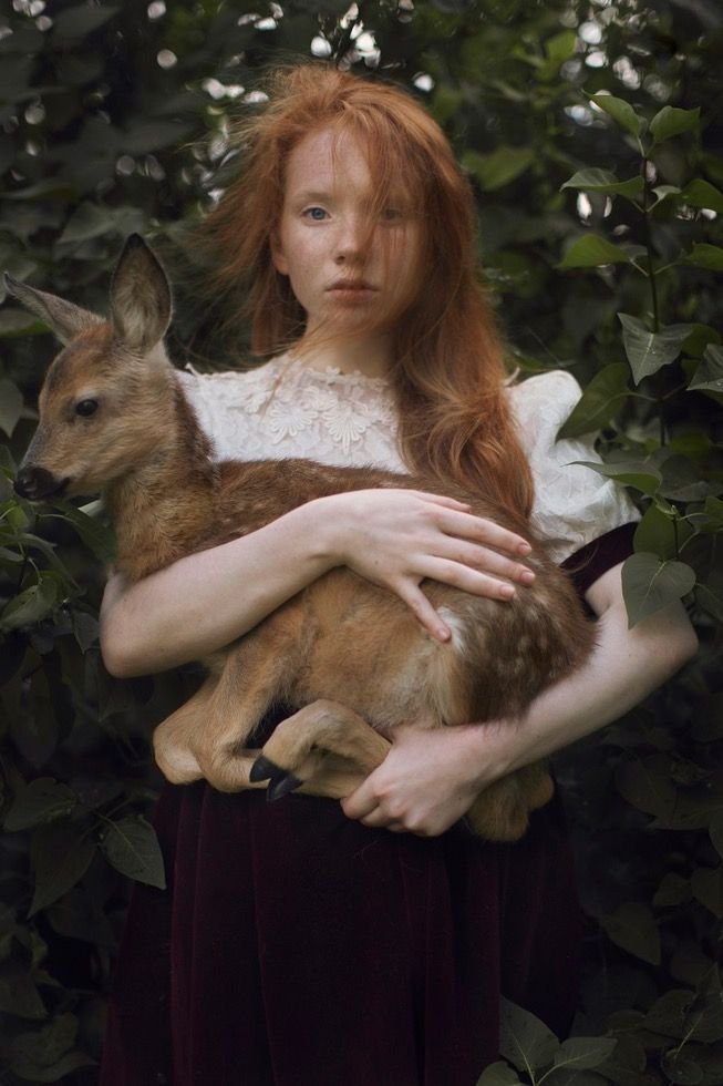 Square portrait profile picture featuring a person wearing a deer-inspired knit bonnet