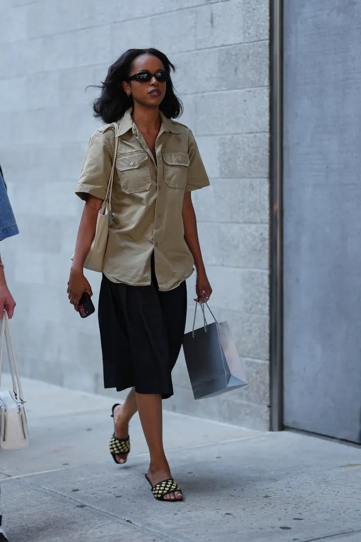 Woman in a light utility shirt for summer, featuring rolled sleeves and white shorts.
