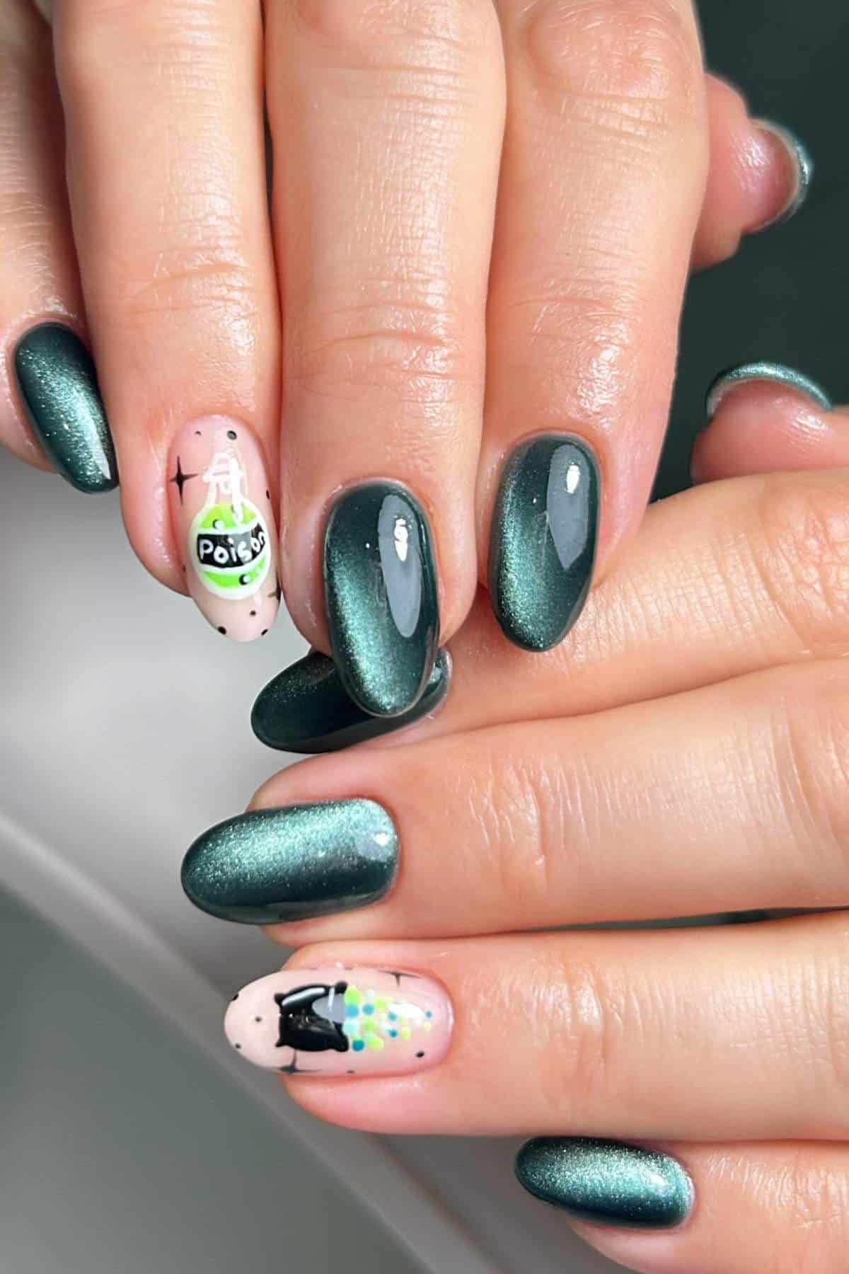 Hands with metallic green nail polish; two accent nails feature detailed designs, one with a “Potion” bottle and the other with a black cat and colorful spots.