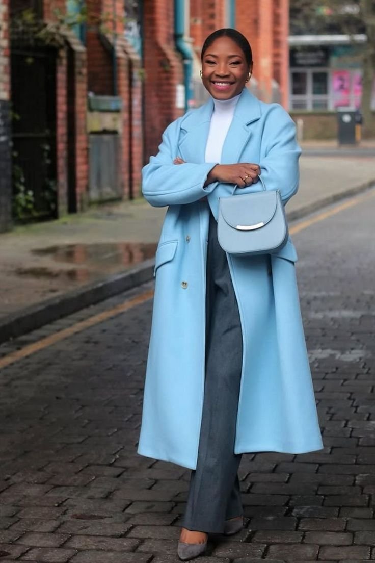 A casual yet elegant icy blue outfit featuring a long sweater, light wash jeans, and white sneakers, perfect for daily wear.