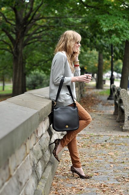 Various accessories like scarves and keychains shown complementing satchel bags.