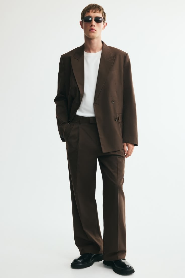 Professional woman in a dark grey chic baggy suit outfit with a white blouse