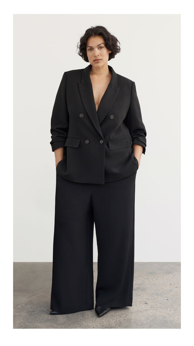 Woman in a neutral-toned baggy suit outfit embodying a modern aesthetic