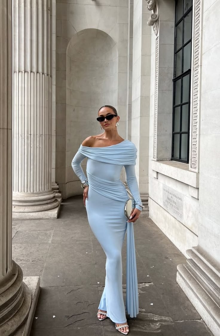 A woman with sleek, styled hair wearing an icy blue top, illustrating how hair can frame and enhance the outfit.