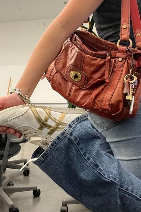 Denim jacket and jeans paired with a rugged leather satchel bag for everyday style.