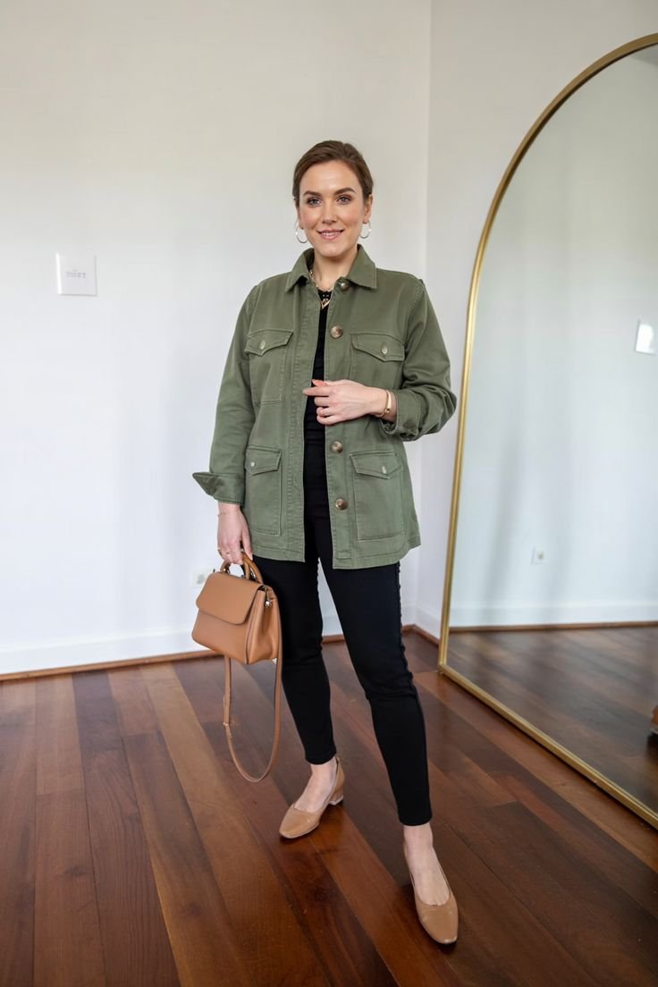 Woman in a sleek black utility shirt outfit, paired with black trousers and minimalist accessories.