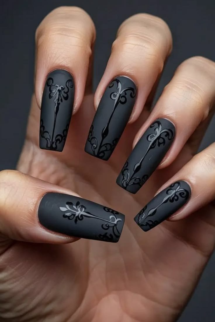 Stylish gothic coffin nails featuring a mix of black, silver, and intricate lace-like patterns.