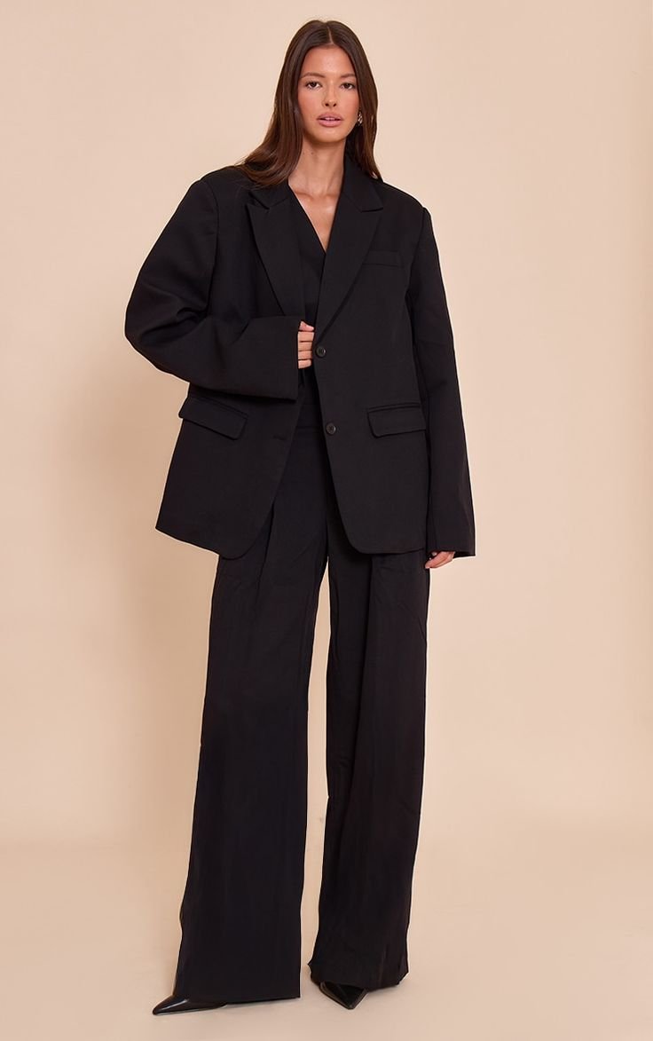 Woman pairing a baggy suit outfit with stylish sneakers and a modern bag