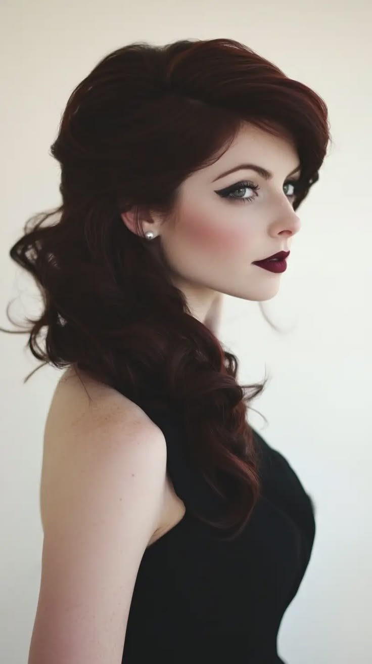 A person wearing a dark, elegant, flowing gown with intricate details, reflecting vampire fashion